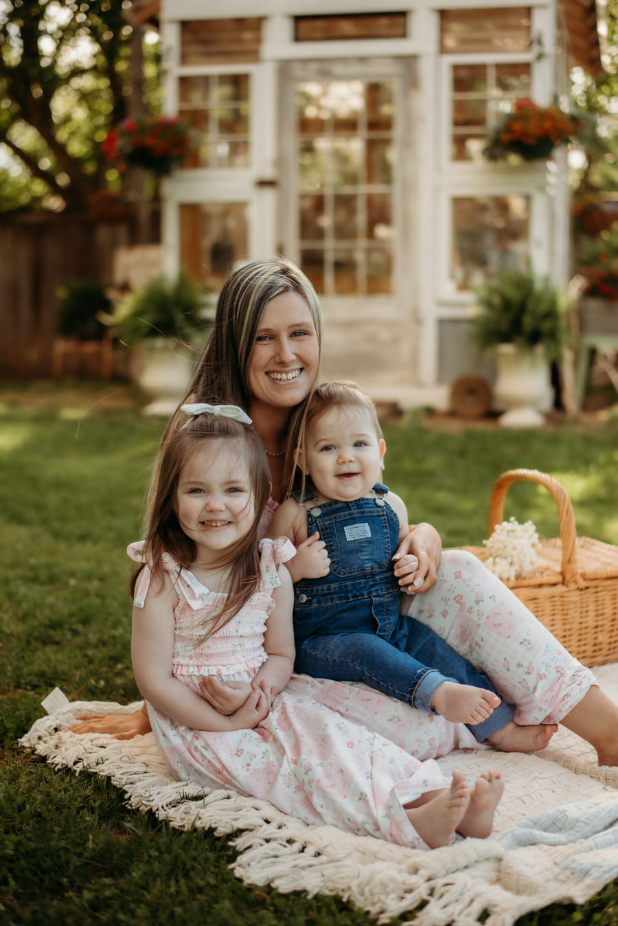 Kearstin Zumwalt sitting on a blanket outdoors with her two children on a summer afternoon.